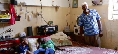 Abu Amir with his children inside their home, pointing out the cracks in the walls, caused during the 2014 conflict. Photo: Alison M. Martin/Oxfam