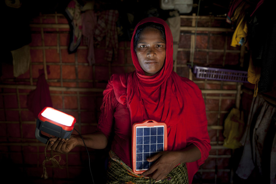 Rohingya refugee Asia Bibi* with solar panels provided by Oxfam, in her shelter in the camps in Cox’s Bazar, Bangladesh. Photo: Abbie Trayler-Smith/ Oxfam