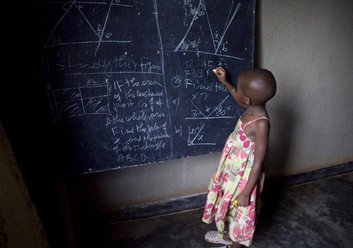 Ecolière devant un tableau noir dans une salle de classe de Kigali, Rwanda. Photo : Simon Rawles