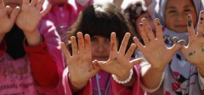 Syrian refugee children in Za'atari camp make the dove symbol of peace 