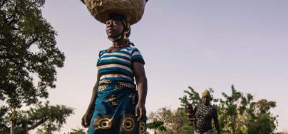 guiratou Ouedraogo, farmer in Burkina Faso, fetches water from a well to water her  market garden crops.