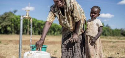 Ellina and her daughter collect water from a tap connected to an Oxfam solar-powered piped water system, Bubi District, Zimbabwe. Photo: Aurelie Marrier d’Unienville/Oxfam