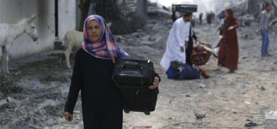 A woman returns to Shujaiya in eastern Gaza (July 2014). Iyad al Baba/Oxfam