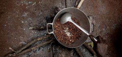 An internally displaced woman grills peanuts on the Cesacoba displacement site, near Bangassou, Central African Republic.