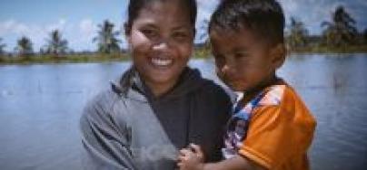 An Indonesian woman shrimp farmer with her child. Photo by Michael Glowacki.