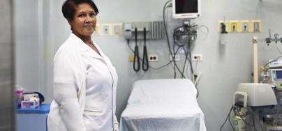 Care giver stands in front of hospital equipment 