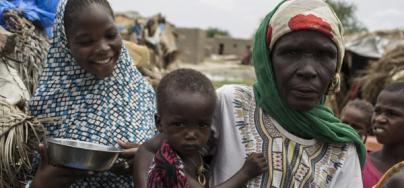 Amina*, 55, a mother of 12, stands with her children outside their hut in the village of Toumour in north eastern Niger, on September 6, 2016. Photo: Pablo Tosco/Oxfam