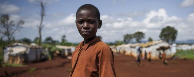 A young refugee from Burundi stands in the Nyarugusu refugee camp in Tanzania on March 26, 2016. According to UNHCR, Nyarugusu is “one of the largest and most overcrowded refugee camps in the world”, currently hosting over 140,000 refugees.