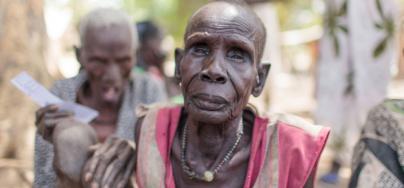 Majok en el centro de registro para la distribución de alimentos del Programa Mundial de Alimentos en Nyal. Ayudado por sus familiares, tuvo que caminar durante hora y media desde su casa para estar presente físicamente en el registro. Fotografía: Bruno B