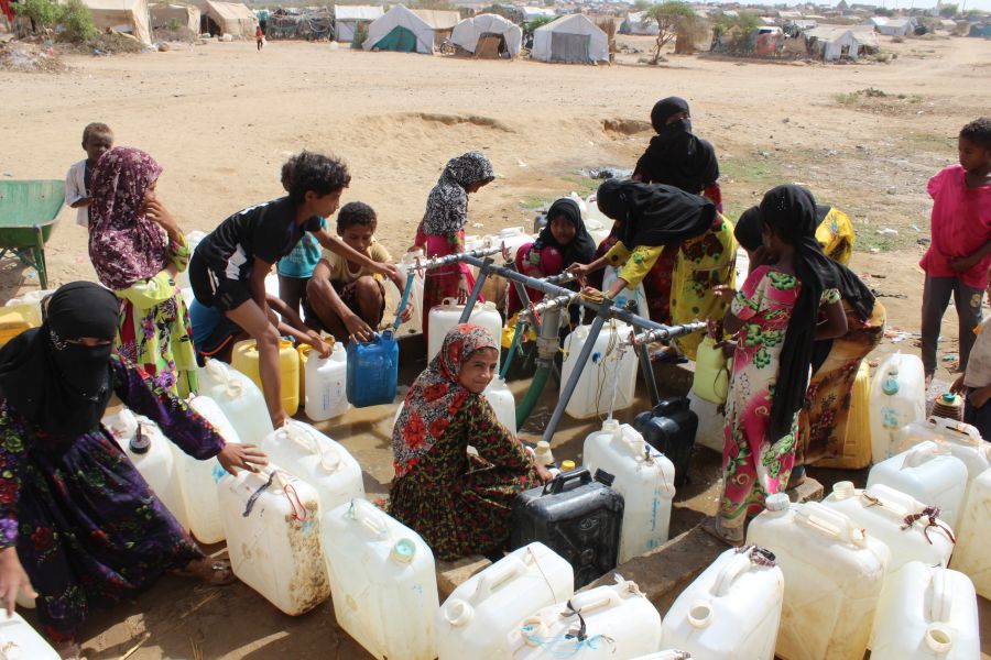 Des déplacés font des réserves d'eau à un point de distribution installé par Oxfam dans le camp de Al-Manjorah, au Yémen.