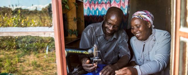 Opheus Dube teaches tailoring skills to his wife Paulina Sibanda in their home in Zvishevane region, Zimbabwe. Credit: Aurelie Marrier d'Unienville / Oxfam