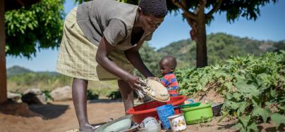 28 years old Edna washes dishes outside her home in Masvingo District, Zimbabwe.