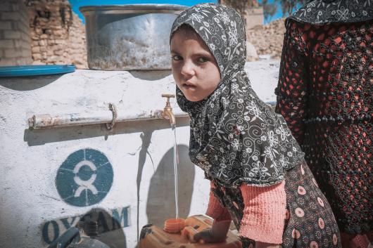 Girl while filling her jerrycan with water in one of the water points constructed by Oxfam in an Amran governorate village, Yemen. Credit: Sami M Jassar/Oxfam