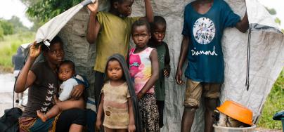 Maria, 31, with her six children with their only belongings sheltering from the rain by the side of the road.