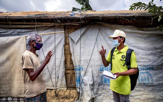 Oxfam volunteer Zahid Hossain (20) is talking to Abdul Malek* (80) about precaution elderly has to take during Covid19 outbreak in the camp. Cox's Bazar, Rohingya refugee camp. Bangladesh. 