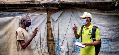 Oxfam volunteer Zahid Hossain (20) is talking to Abdul Malek* (80) about precaution elderly has to take during Covid19 outbreak in the camp. Cox's Bazar, Rohingya refugee camp. Bangladesh. 