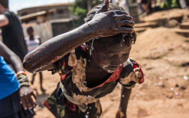 Mariama, 13, uses a new borehole installed by Oxfam as part of ongoing water and sanitation work following the Ebola crisis in Sierra Leone. Photo: Tommy Trenchard/Oxfam