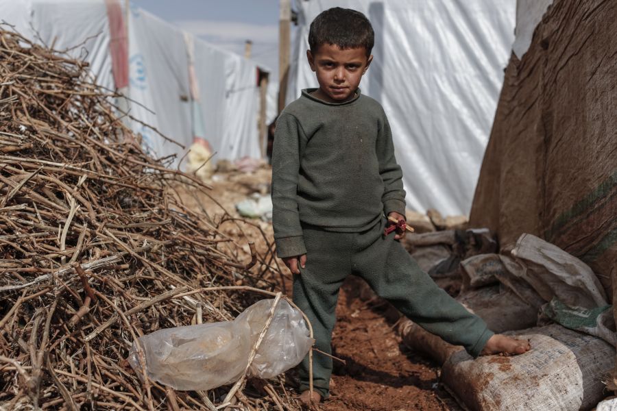 Malik, 7, from Raqqa in Syria, stands barefoot amid the mud, in an informal settlement for Syrian refugees in Lebanon’s Bekaa Valley.