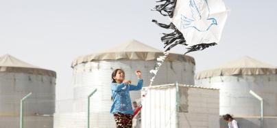 A young girl flies a kite in Za'atari camp. Photo credit: Adeline Guerra/Oxfam