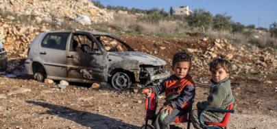 Yasser, four, and Ibrahim, three, sit on a bike. Photo: Tanya Habjouqa/Oxfam