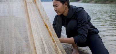 Hong Rany (26) checks a net for fish near her home on Chrem Island out in the middle of the Mekong River. 