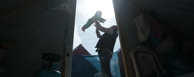 A father plays with his 3-year-daughter in the middle of his tent in Rafah which he took refuge after losing his house and factory.