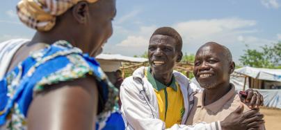 Richard (middle), a refugee and pastor at the Imvepi refugee settlement in Uganda, meets an old friend in the settlement's market. Credit: Coco McCabe/Oxfam